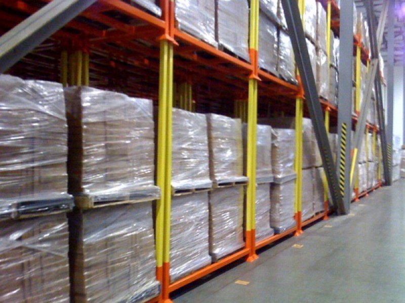 Stack racks with wrapped pallet loads in warehouse aisle